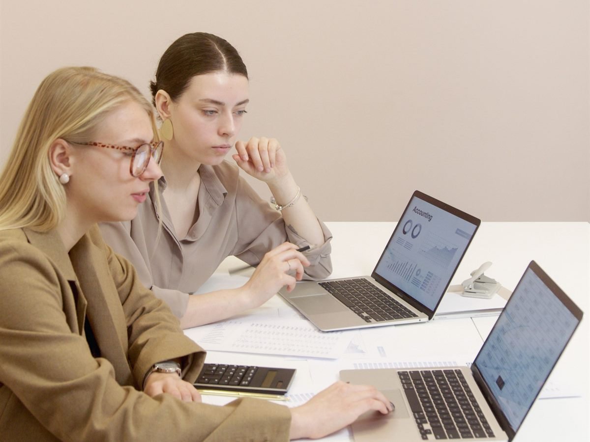 Dos profesionales revisando informes financieros en el portátil